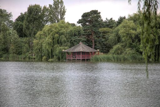 A red gazebo on the bank of a river