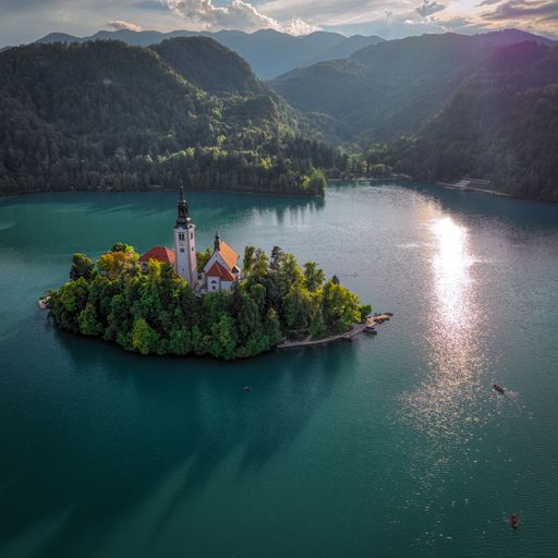 The Church and Castle in Lake Bled, Slovenia with mountains and lush trees in the background