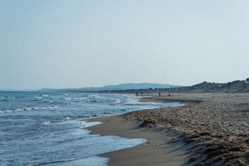 A beautiful scene of the Playa de la Marina beach with blue sea waves reflected from the sky in Alicante, Spain