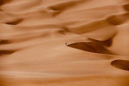 A person walking on sand dunes in a desert