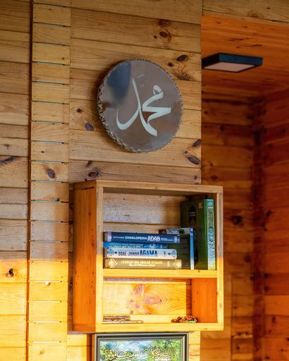 Perak, Malaysia - Oct 19, 2022 Islamic books and Muhammad wall sign in prayer room at Kuak Hill Resort in Lenggong.