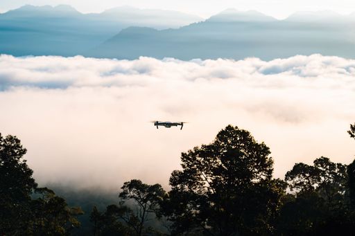 Drone flying above the Sea clouds during golden sunrise near the rainforest trees in Lenggong, Perak.