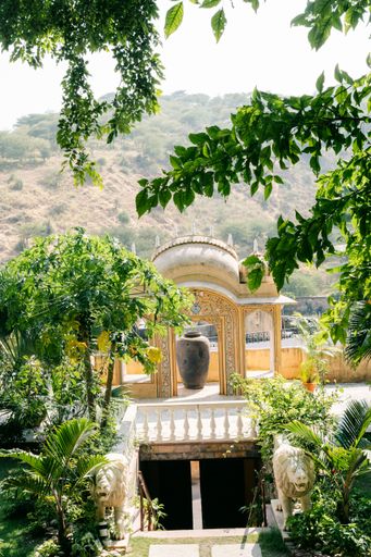 A vertical shot of an arch in Galtaji pilgrimage with mountains in the background, Rajasthan, India