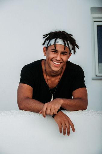 A vertical shot of a Hispanic attractive boy smiling at the camera