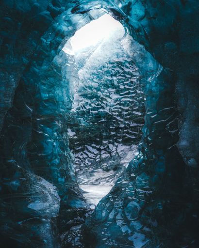 A vertical shot of a blue ice cave in Iceland