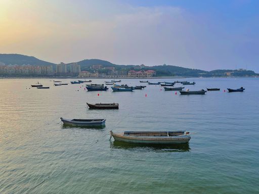 A high angle shot of fishing boats floating near a harbor in the afternoon in Weihai, China