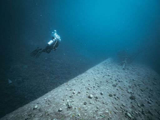 A diver diving through an underwater wreck in the Red Sea.