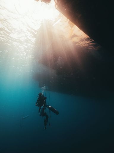 A diver diving through an underwater wreck in the Red Sea.