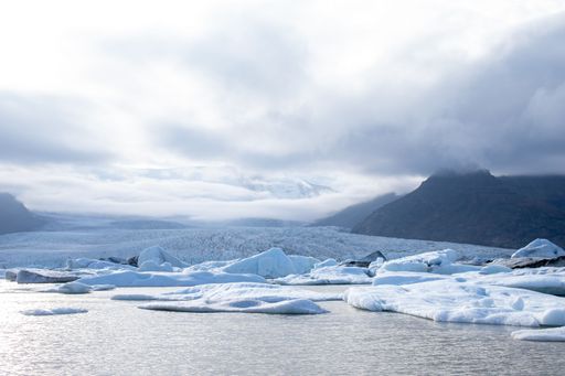 The Fjallsarlon glacial lake with floating ice caps against the foggy sky in Iceland