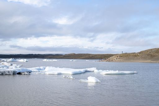 The Fjallsarlon glacier lake with floating ice caps against the cloudy sky in Iceland