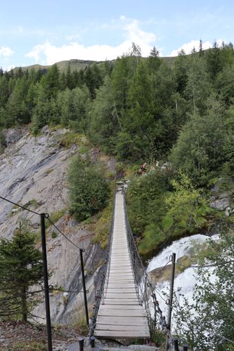 A vertical shot of a long rope bridge over a stream in the Mont Blanc Mountains