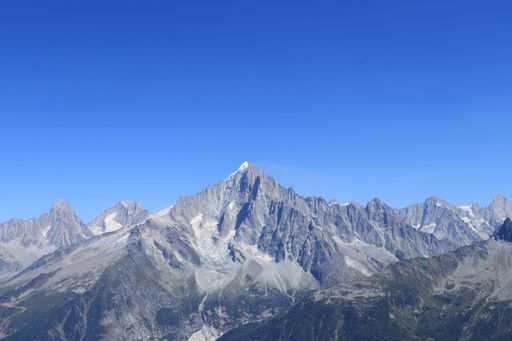 An aerial view of the beautiful Mont Blanc mountains under a bright blue sky