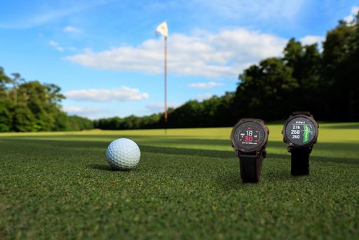 A closeup of smartwatch and golf ball in golf field