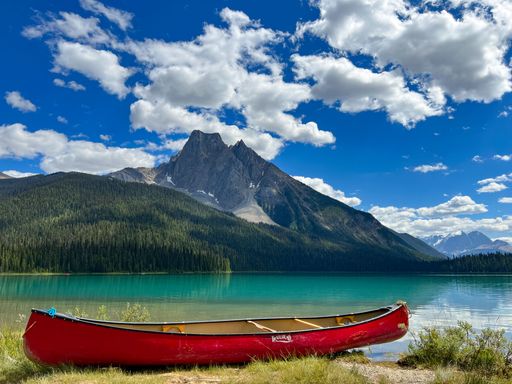 The view of a canoe at the Emerald lakeshore before the mountains in British Columbia