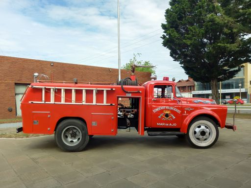 Old classic red 1950s Chrysler Fargo 500 fire truck pumper tanker outdoors.