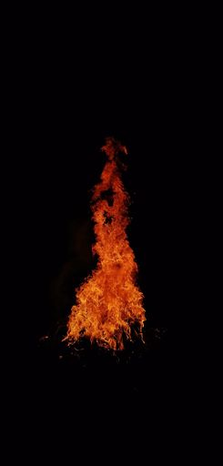 A vertical of a bonfire burning in the dark