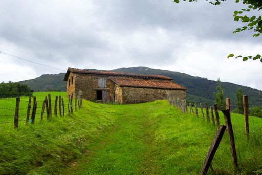 The cloudy sky over the old house barn in the green land