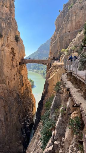 A group of tourists walking across a bridge over a gorge, Caminito del Rey