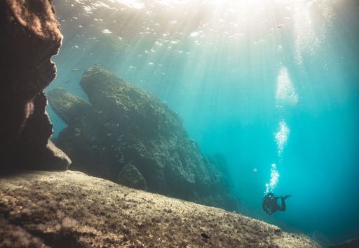 A scuba driver in a special dress exploring the underwater riffs of the blue ocean