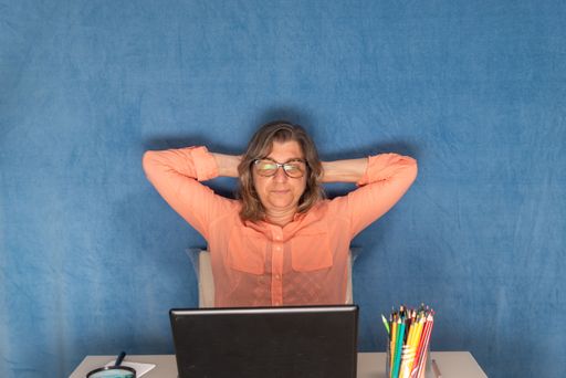 Happy woman with laptop computer working from home or office. Business, people and technology concept.