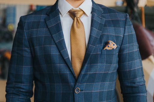 A close-up shot of a man wearing a blue plaid suit