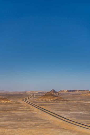 A vertical aerial shot of the road through the Black Desert, Egypt.