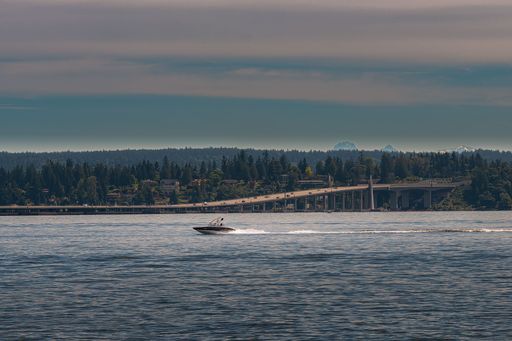 A motorboat in Washington lake, and the 520 floating Bridge on the horizon in Seattle, USA