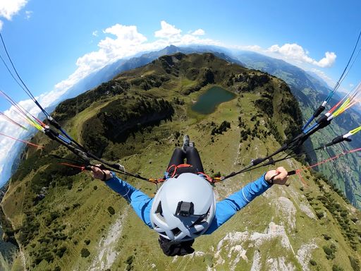 A top view of a skydiver paragliding on a scenic landscape with a parachute