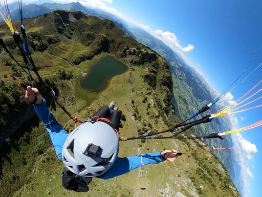 A top view of a skydiver paragliding on a scenic landscape with a parachute