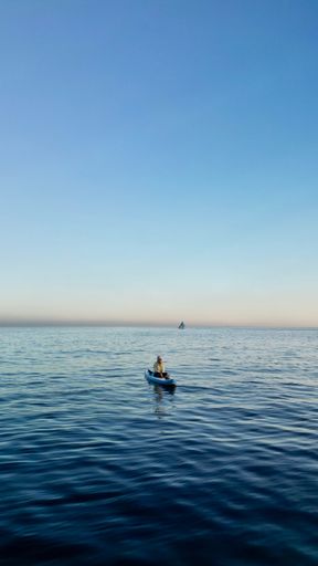A vertical shot of a person in a kayak floating on the water in Bali, Indonesia