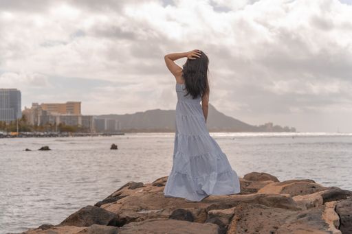 A beautiful shot of a woman in a long dress posing in Honolulu, Hawaii