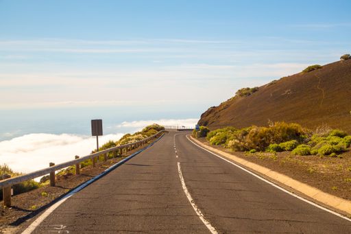 A closeup of a smooth road above the clouds leading to the volcano Teide on Tenerife