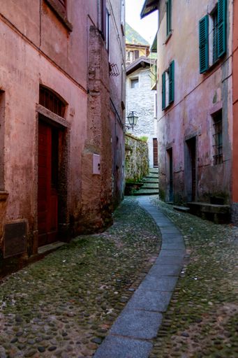 A vertical shot of a narrow alley between buildings in Argegno Italy