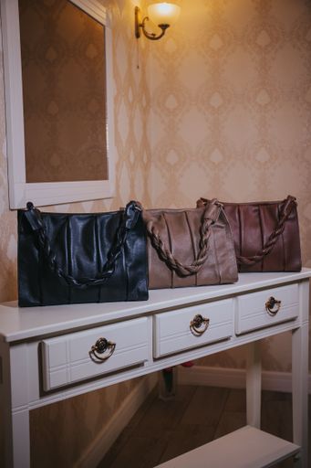 Three fashionable leather bags on the table in the room