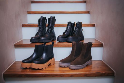 A closeup of black and brown boots on staircases