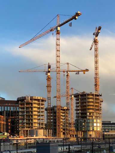 A vertical shot of a building construction site on a sunny day