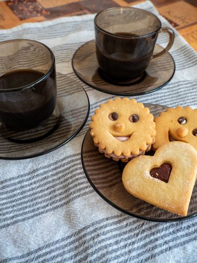 A closeup of  cups of coffee with cookies