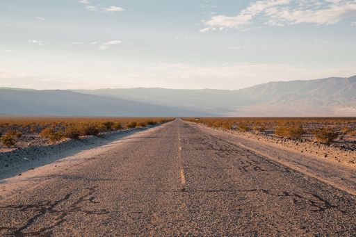 A long road leading to the picturesque hills through a deserted area