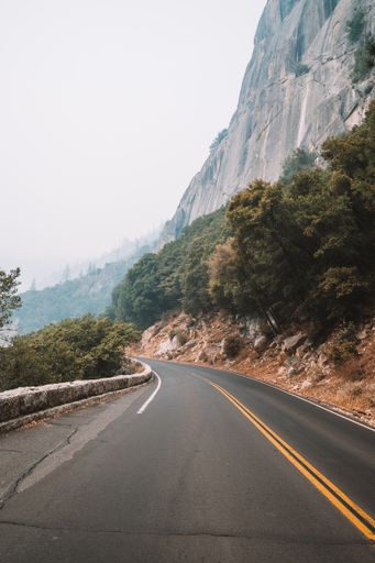 A vertical shot of a road surrounded by rocky cliffs in the Yosemite National Park