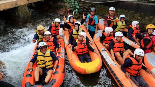 A high angle shot of a cheerful team wearing helmets and life jackets for rafting on a river