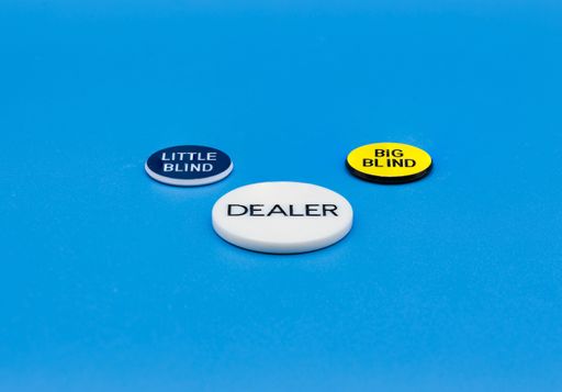 The poker chips and emblems put on the blue poker table and isolated on the blurred background