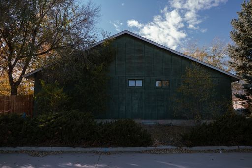 An old house with fall colors around and blue cloudy sky