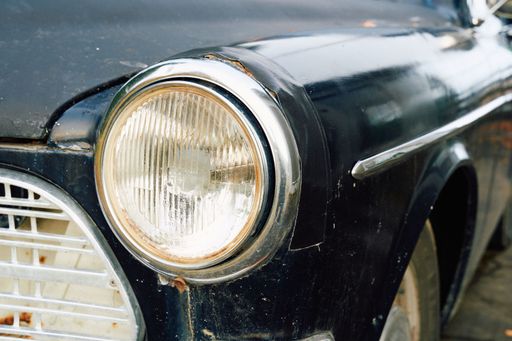 A closeup of a vintage black car's headlights in Toten, Norway in late October