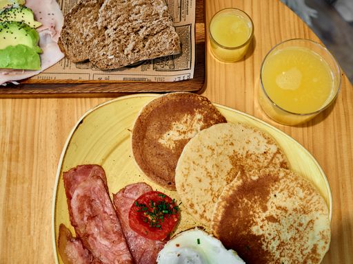 A top of view of American breakfast with eggs, bacon, toast, pancakes