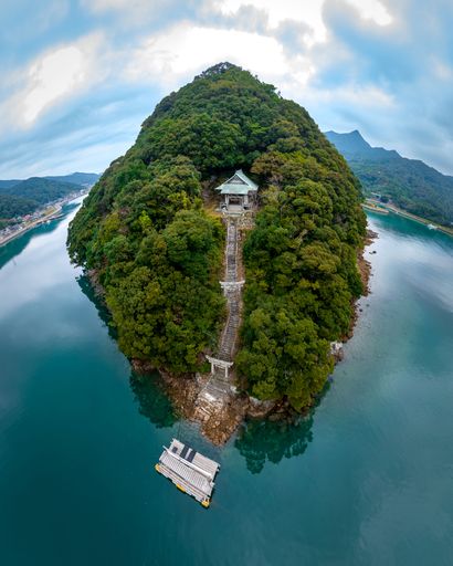 An aerial view of greenery island surrounded by water