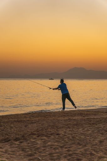A male fishing in a lake at sunrise, Turkey