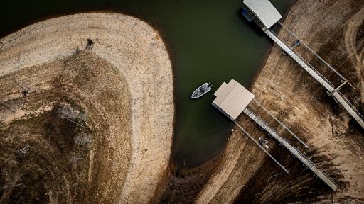 A top view of a bass fisherman fishing near a dock in a small cove on lake