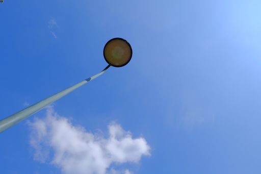 A low angle shot of a street light post on a blue sky background
