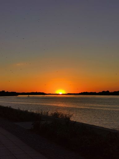 A beautiful view of an orange sunset over the lake.