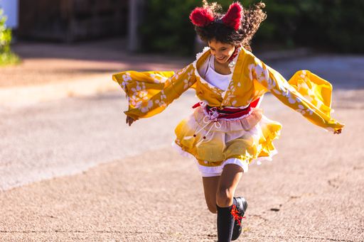 A cute jumping girl kid in the Fort Worth Japanese Gardens at a fall festival